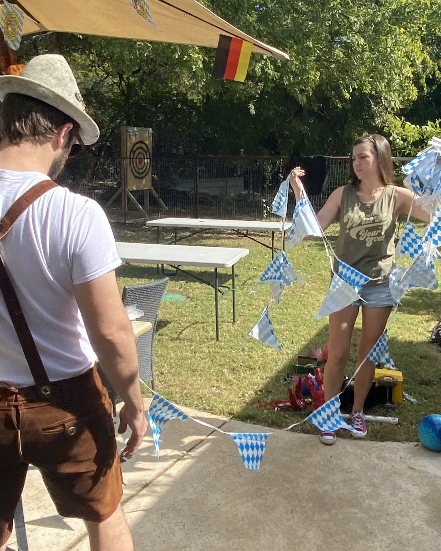 A festival guest in lederhosen beneath the tent umbrella